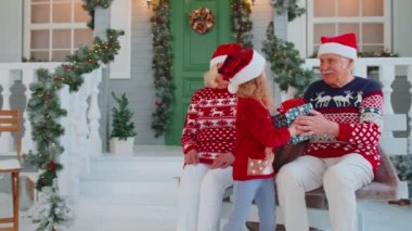 Torunum Noel Noel hediyesi kutusunu evde şaşırmış mutlu büyükanne ve büyükbabasına hediye ediyor.