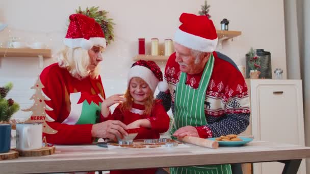 Grappige senior grootouders en kleindochter spelen met bloem smeren op gezicht in de kerstkeuken — Stockvideo