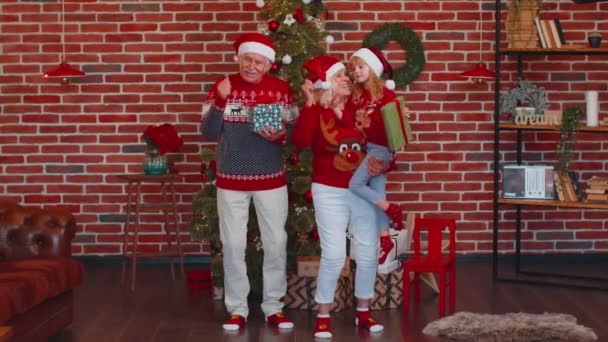 Fröhliche alte Großeltern mit Enkelkind tanzen zu Hause neben geschmücktem Weihnachtsbaum — Stockvideo