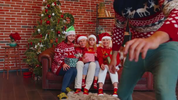 Hombre establece temporizador en el teléfono móvil tomando multigeneracional familia selfie retrato celebrando la Navidad — Vídeo de stock