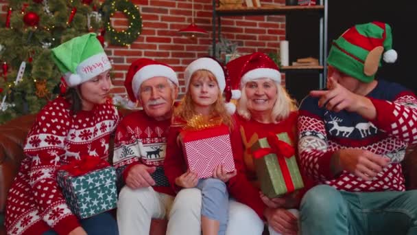Семья из нескольких поколений делает селфи-фото на таймере мобильного телефона в украшенном доме Рождества — стоковое видео
