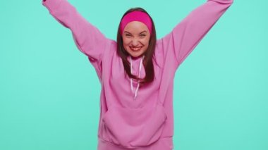 Pembe kapüşonlu genç kız bağırıyor, el kol hareketi yapıyor Başarımı kutluyorum, kazanıyorum