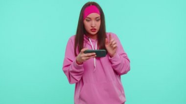 Endişeli komik bağımlı kadın kız hevesle cep telefonuyla yarış oyunları oynuyor.