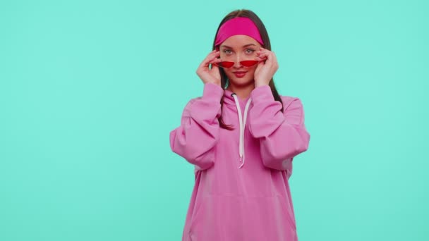 Sedutor alegre positivo adolescente menina com capuz usando óculos de sol, sorriso encantador, olho piscando — Vídeo de Stock
