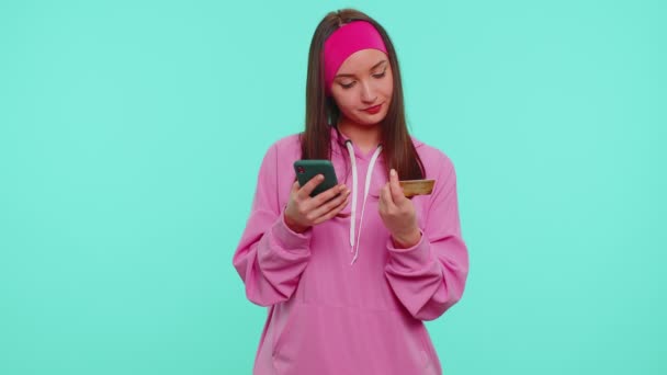 Teenager-Mädchen nutzt Kreditkarte und Smartphone beim Geldtransfer, kauft online ein — Stockvideo