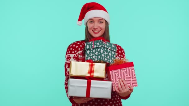 Mulher em camisola vermelha de Natal, chapéu de Santa sorrindo segurando muitas caixas de presente Ano Novo apresenta compras — Vídeo de Stock