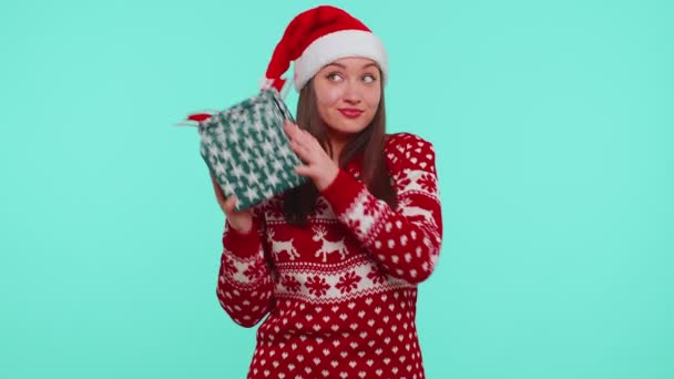 Funny girl porte le chandail de Noël reçu cadeau, intéressé par ce qui à l'intérieur boîte cadeau — Video