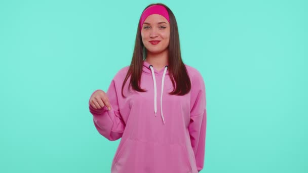 Teenie-Mädchen zeigt nach unten, sagt zu abonnieren, gestikuliert ok und like, zeigt Platz für Werbung — Stockvideo