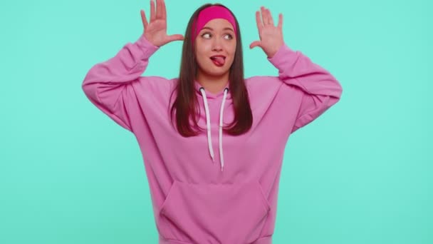 Rolig tonåring flicka att göra lekfulla dumma ansiktsuttryck och grimma, lura runt visar tunga — Stockvideo
