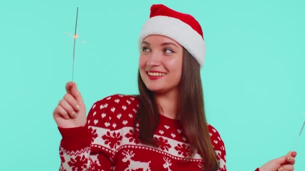 Chica encantadora en Navidad Santa suéter bailando con bengala chispas fuegos artificiales ligts, felicitaciones — Vídeo de stock