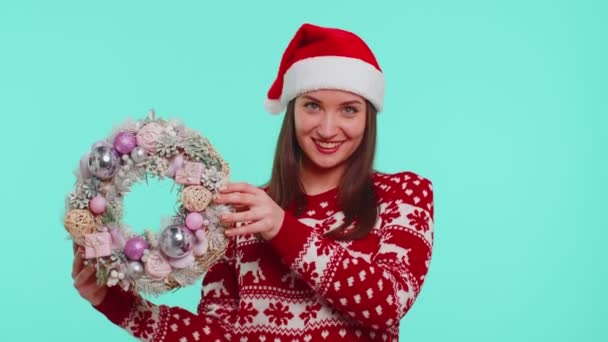 Adulto sorridente menina em vermelho Natal feriado suéter segurar levantar dedo ponto no brinquedo grinalda festiva — Vídeo de Stock