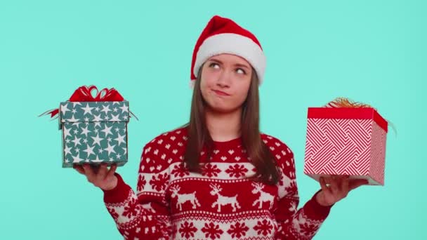 Mujer en jersey rojo de Navidad Santa sombrero, sonriendo, sosteniendo dos cajas de regalo de Año Nuevo regalos de compras — Vídeos de Stock