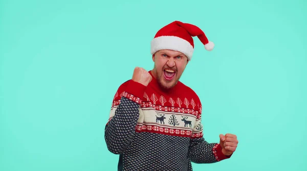 Веселый человек в красном свитере Рождество Санта кричит, празднуя успех, победы, цели достигаются — стоковое фото
