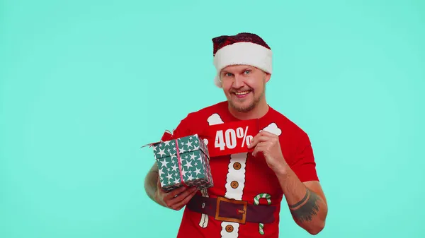 Мужчина в красной рождественской футболке с подарочной коробкой и 40-процентной надписью со скидкой — стоковое фото