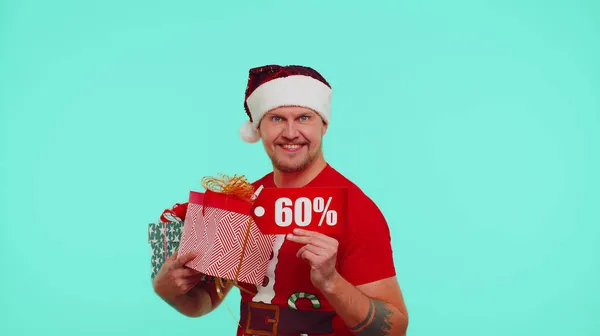 Мужчина в рождественской футболке с подарочными коробками и 60-процентными надписями со скидкой — стоковое фото