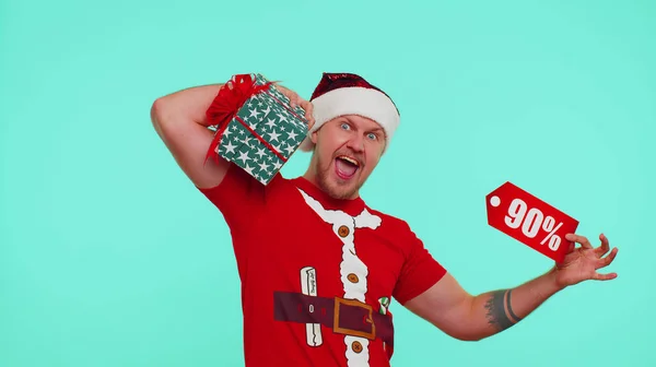 Чоловік у червоній різдвяній футболці, що показує подарункову коробку та 90 відсотків знижки написи банер текстова нотатка — стокове фото