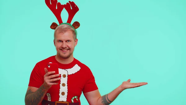 Tシャツの男サンタクリスマスで携帯電話を示す空の場所,広告エリア — ストック写真