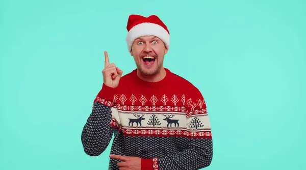 Homem animado em camisola de Natal vermelho fazer gesto levanta dedo veio com plano criativo boa ideia — Fotografia de Stock