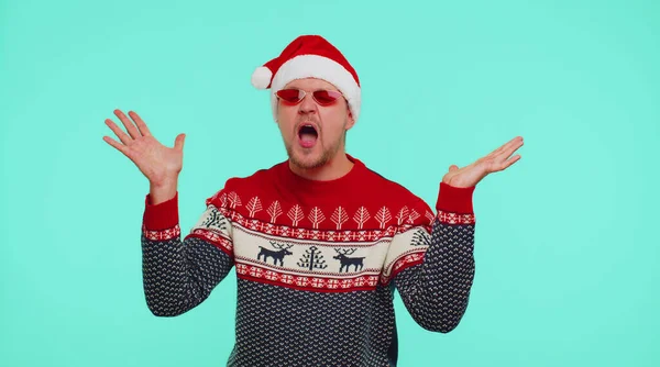クリスマスセーターの男はイヤホンを介して音楽を聞いて、楽しみを持って周りを欺くディスコを踊る — ストック写真