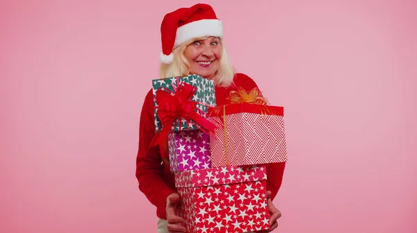 Зрелая бабушка женщина в рождественском свитере проведение много подарочных коробок Новогодний подарок покупки — стоковое фото