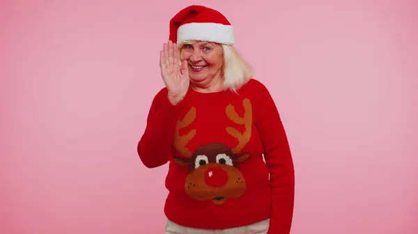 Avó mulher em camisola de Natal com veados ondas mão palma em Olá gesto recebe alguém — Fotografia de Stock