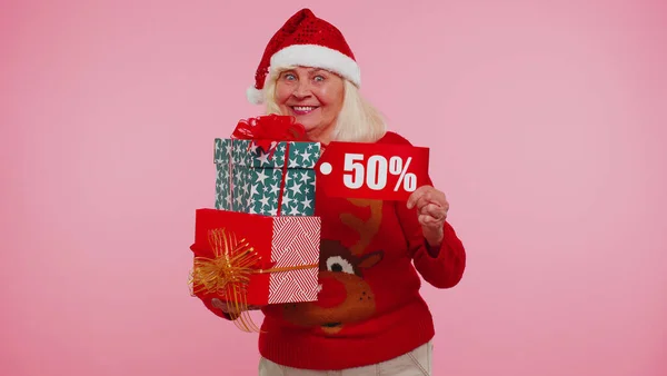 Пожилая женщина в рождественском свитере с подарочной коробкой и 50-процентной скидкой — стоковое фото