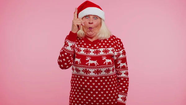 Бабуся в різдвяному светрі змушує жест піднімати палець придумав креативний план хороша ідея — стокове фото