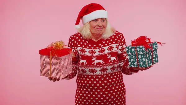 クリスマスセーターのシニア祖母女性は手に2つのギフトボックスを持っています、ショッピング休日の販売 — ストック写真