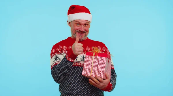 Wesoły człowiek w swetrze Santa Boże Narodzenie kapelusz coraz prezent pudełko, wyrażając zdumienie szczęście — Zdjęcie stockowe
