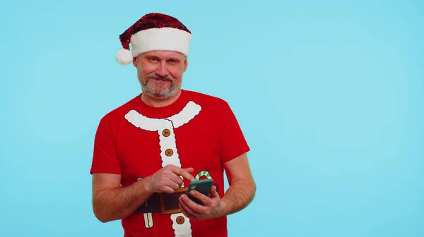Homem de t-shirt de Natal, chapéu usando telefone celular digitando novo post na web, compras on-line, navegação — Fotografia de Stock