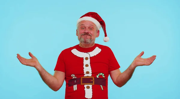 Запутавшийся мужчина в рождественской футболке стесняется двусмысленного вопроса, не имея ни малейшего понятия — стоковое фото