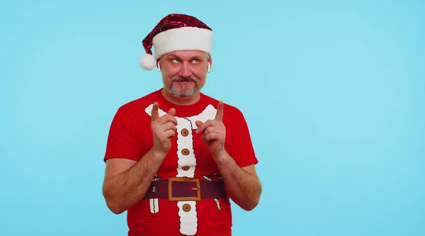 Мужчина в рождественской футболке слушает музыку через наушники, танцует диско, развлекается — стоковое фото