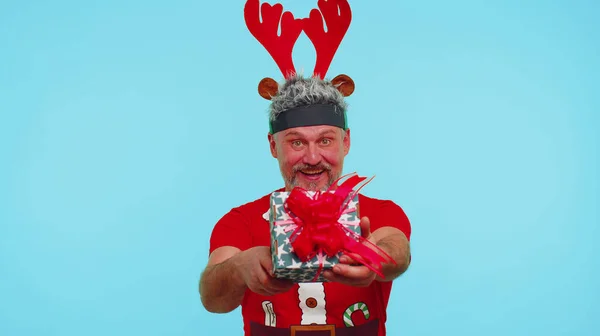 Rolig man bär röd nyårströja och hatt presenterar julklapp låda, shopping försäljning semester — Stockfoto