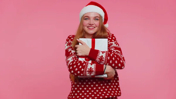 Fille joyeuse dans le chandail de Noël Père Noël obtenir boîte cadeau, exprimant le bonheur étonnement — Photo