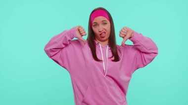 Pembe kapüşonlu üzgün kız baş parmağını kaldırıyor işaret işareti yapıyor, onaylamıyor, tatminsiz, hoşnutsuz