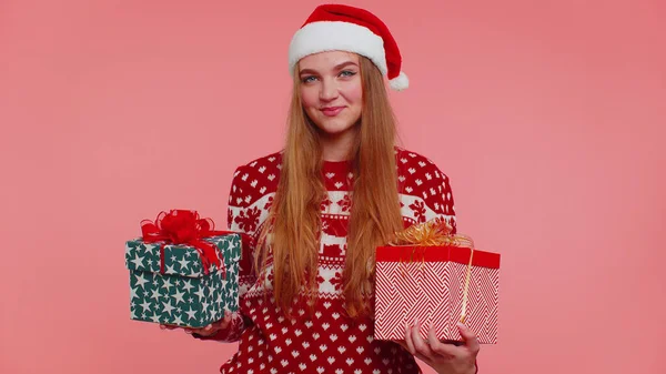 Mulher em camisola vermelha de Natal chapéu de Santa, sorrindo, segurando duas caixas de presente Ano Novo apresenta compras — Fotografia de Stock