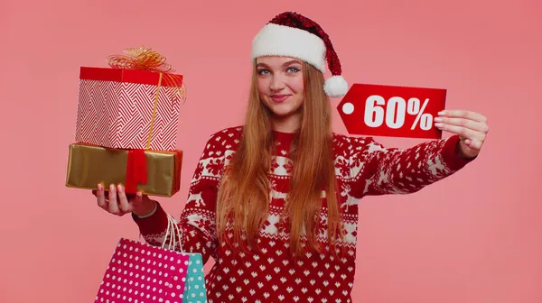 Жінка в різдвяному светрі показує подарункові коробки та 60 відсотків знижки написи банер текстова нотатка — стокове фото