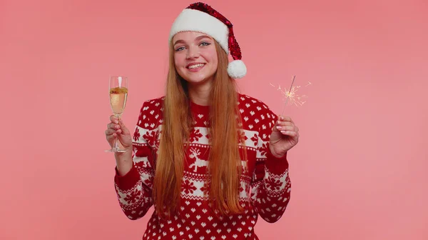 Menina encantadora no Natal Santa camisola dançando com fogos de artifício espumantes bengala e taça de champanhe — Fotografia de Stock