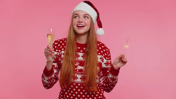 Bella ragazza in Natale Babbo Natale maglione danza con scintille bengala fuochi d'artificio e bicchiere di champagne — Foto Stock