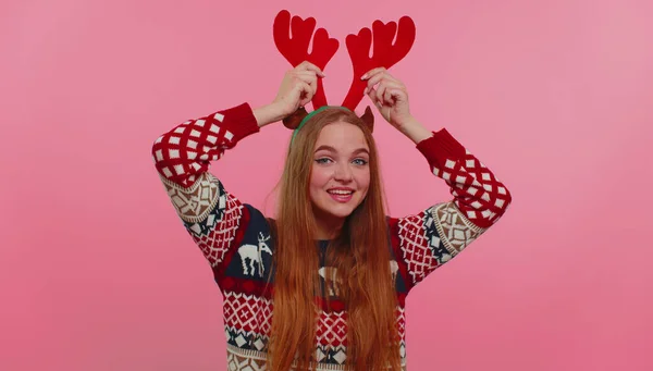Молода дівчина в різдвяних оленячих ролях слухає музику, танцює дискотеку, обманює розваги — стокове фото