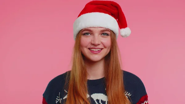 Весела дівчина носить червоний різдвяний светр і капелюх посміхається дивлячись на камеру, З Новим роком — стокове фото