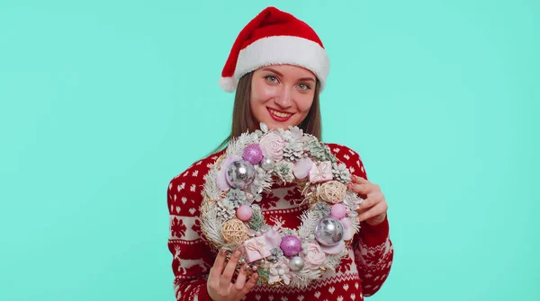 Доросла усміхнена дівчина в червоному різдвяному светрі тримає палець на святковій іграшці — стокове фото