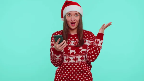 Jeune fille adolescente en pull de Noël regardant l'affichage du smartphone se réjouissant sincèrement gagner la chance de succès — Photo