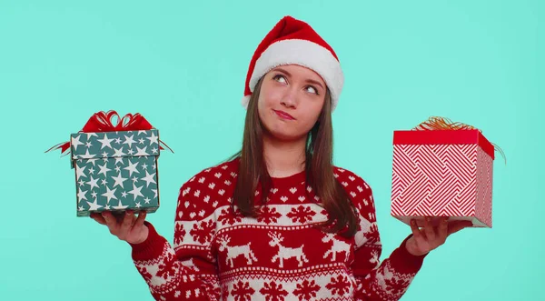 Mulher em camisola vermelha de Natal chapéu de Santa, sorrindo, segurando duas caixas de presente Ano Novo apresenta compras — Fotografia de Stock