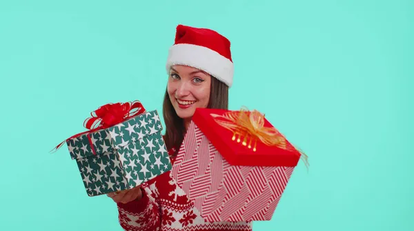 Радісна дівчина в червоному різдвяному светрі представляє дві різдвяні подарункові коробки, розпродаж напередодні свята — стокове фото