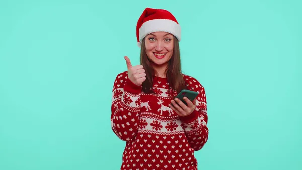 Adulto adolescente menina em camisola de Natal olhando exibição smartphone sinceramente regozijando ganhar sucesso sorte — Fotografia de Stock