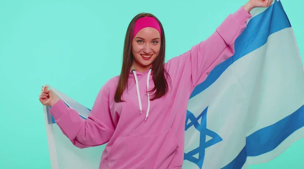Alegre chica adolescente encantadora ondeando y envolviendo en la bandera nacional de Israel, celebrando el día de la independencia —  Fotos de Stock