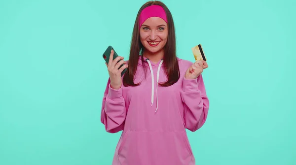 Flicka använda mobiltelefon och plast kreditkort surfa säga wow ja fick reda på stor vinst — Stockfoto