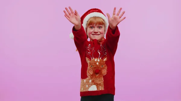 Девушка в рождественском свитере махает ладонью в знак приветствия приветствует кого-то, чтобы отпраздновать Новый год — стоковое фото