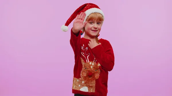 Menina em ondas de camisola de Natal palma da mão em Olá gesto recebe alguém para comemorar o Ano Novo — Fotografia de Stock